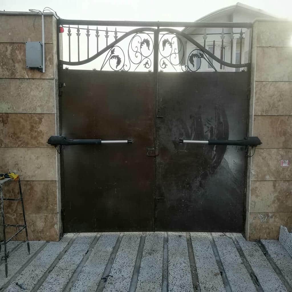 جک درب پارکینگ خاکستری روی دروازه دو لنگه جک درب پارکینگ خاکستری روی دروازه دو لنگه